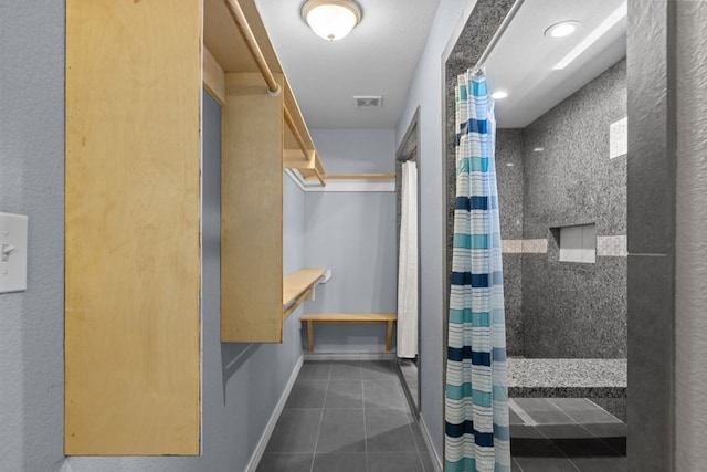 bathroom with tile patterned flooring, baseboards, visible vents, and a shower with shower curtain