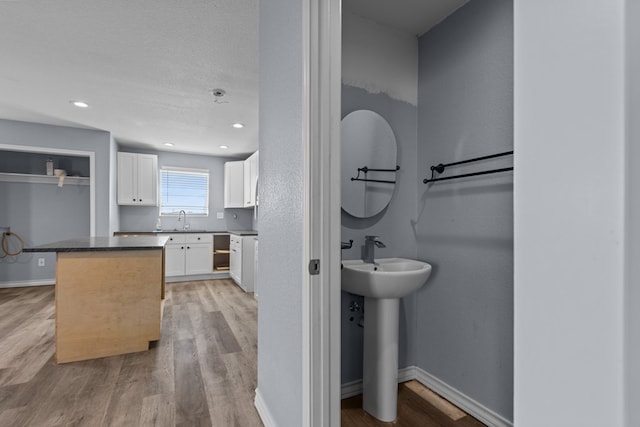 bathroom with recessed lighting, baseboards, and wood finished floors