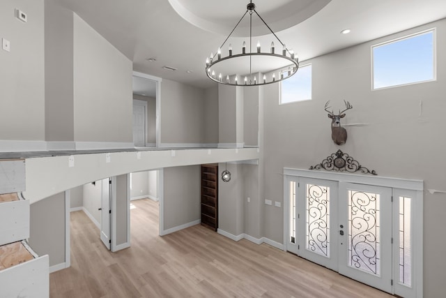 foyer with recessed lighting, baseboards, a notable chandelier, and light wood finished floors