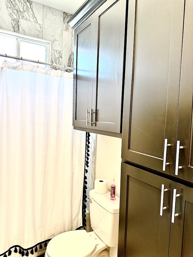 bathroom featuring curtained shower and toilet