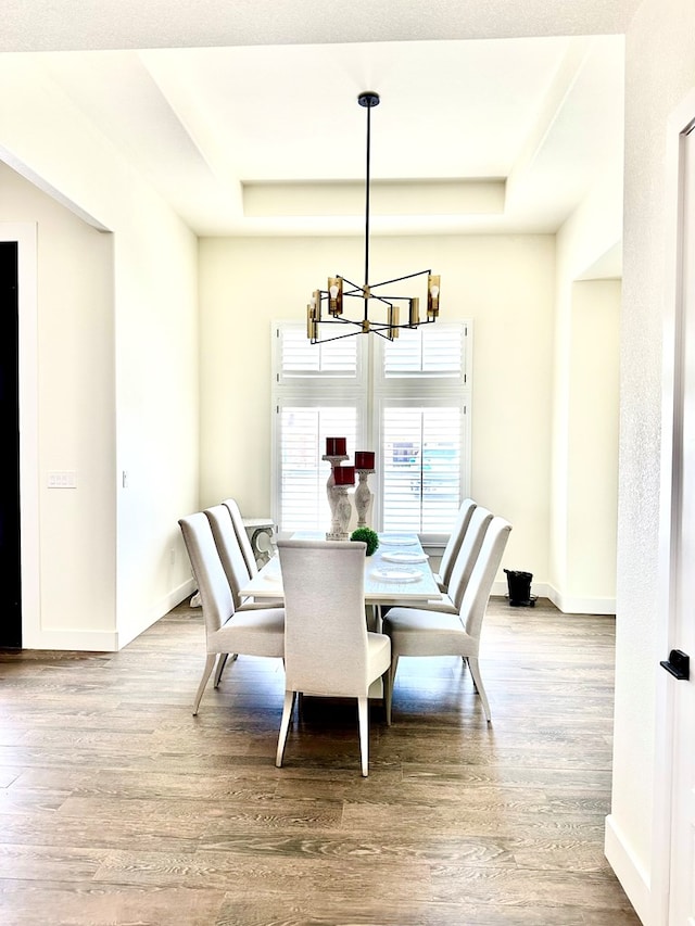 dining room featuring baseboards, a notable chandelier, and wood finished floors