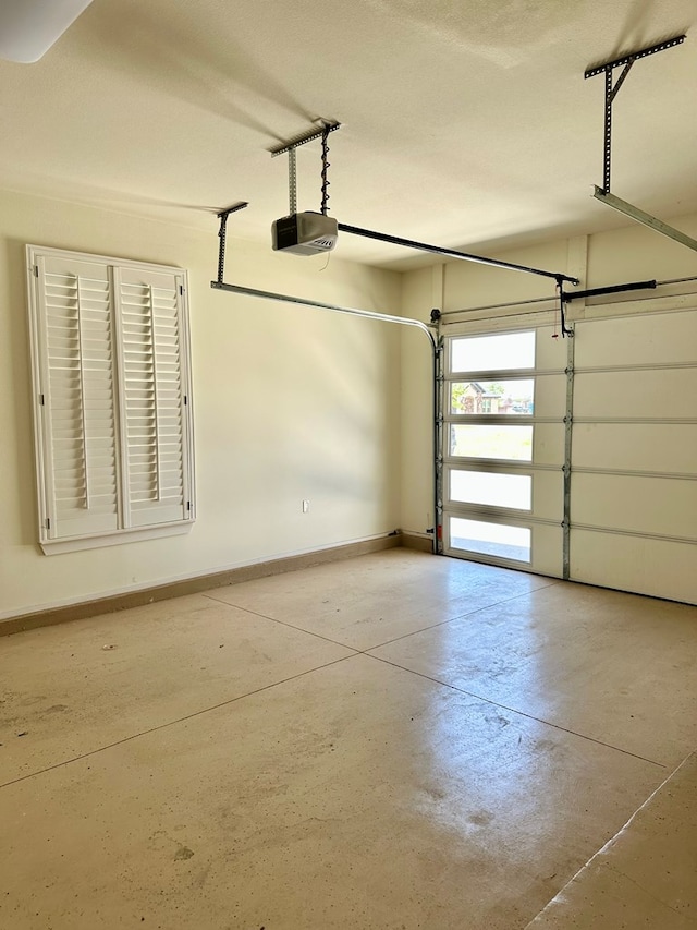 garage featuring a garage door opener and baseboards