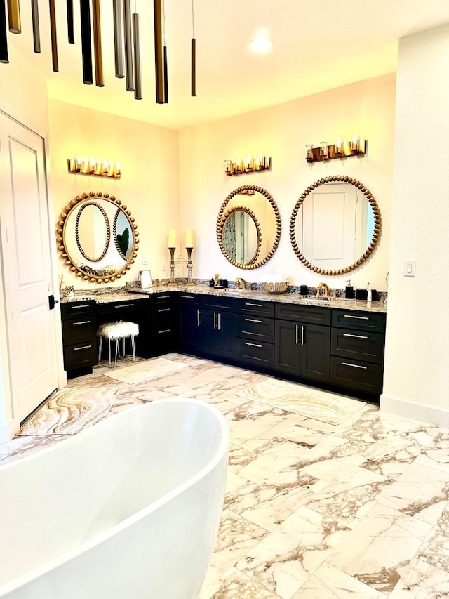 bathroom with baseboards, double vanity, a freestanding tub, marble finish floor, and a sink