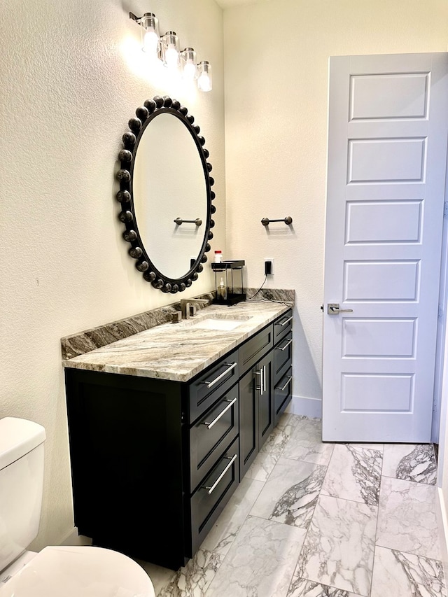 bathroom featuring marble finish floor, toilet, vanity, and baseboards