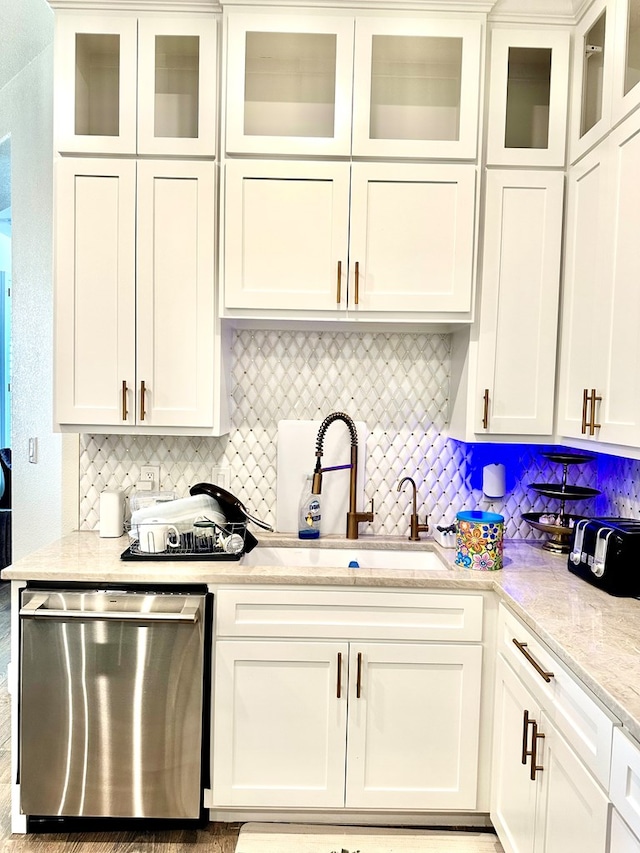 kitchen with a sink, dishwasher, and white cabinetry