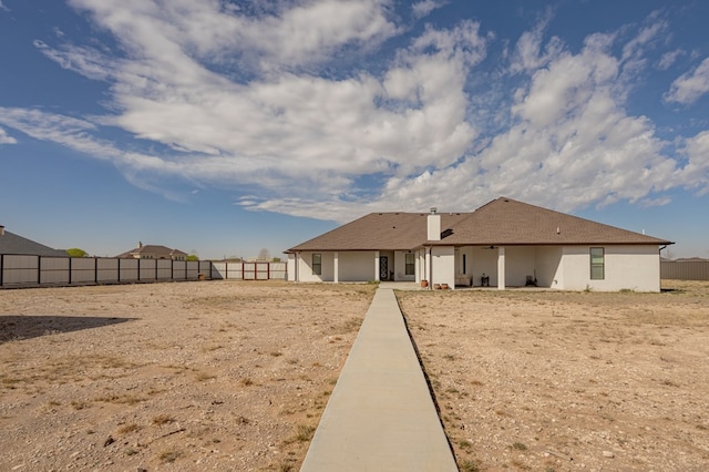 back of house featuring stucco siding and a fenced backyard