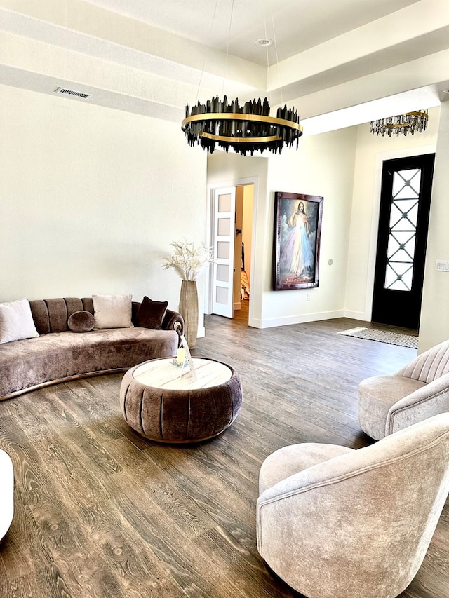 living area featuring visible vents, baseboards, and wood finished floors