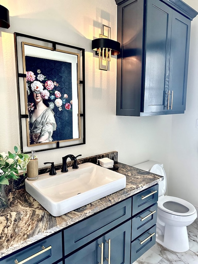 bathroom with vanity, toilet, and marble finish floor