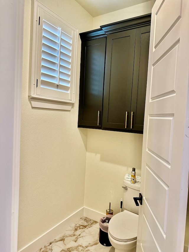 bathroom featuring baseboards, toilet, and marble finish floor