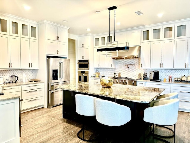 kitchen featuring visible vents, a center island, appliances with stainless steel finishes, light wood-style floors, and white cabinetry