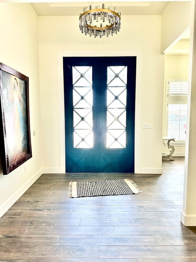 foyer entrance with baseboards and wood finished floors