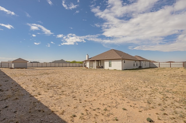 rear view of property featuring a fenced backyard and stucco siding