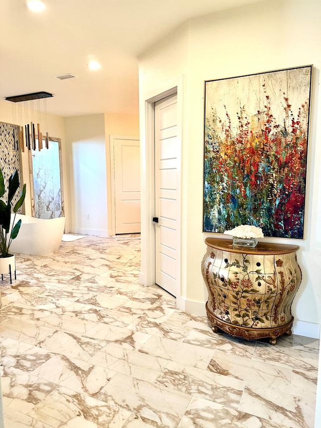 corridor with visible vents, baseboards, and marble finish floor