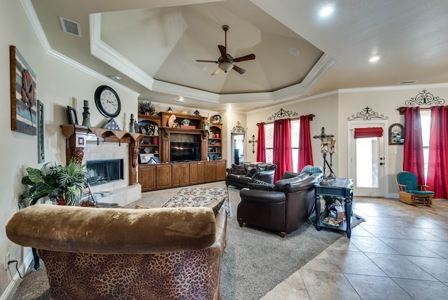 living room with ceiling fan, a healthy amount of sunlight, ornamental molding, and a tray ceiling