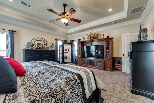 carpeted bedroom with a raised ceiling, ceiling fan, and crown molding