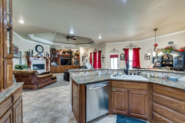 kitchen with stainless steel dishwasher, light stone counters, a raised ceiling, and sink