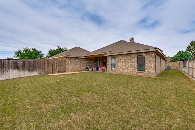 back of property featuring a lawn