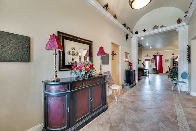 hall with vaulted ceiling, ornate columns, and crown molding