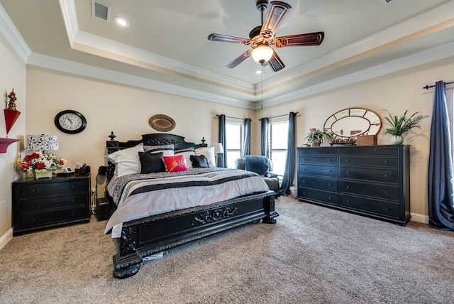 carpeted bedroom featuring a raised ceiling, ceiling fan, and ornamental molding