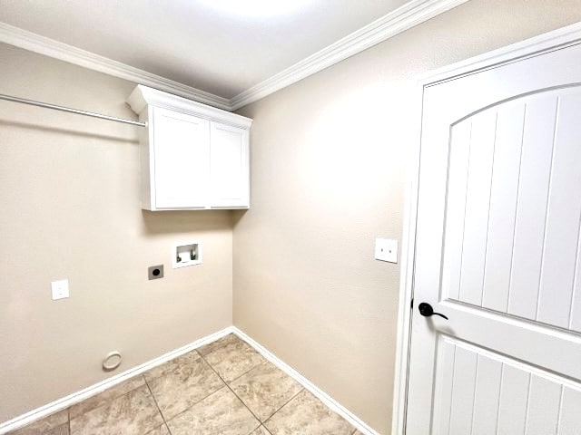 clothes washing area with hookup for an electric dryer, hookup for a washing machine, cabinets, crown molding, and light tile patterned flooring