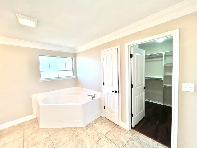 bathroom with tile patterned floors, a bath, and crown molding