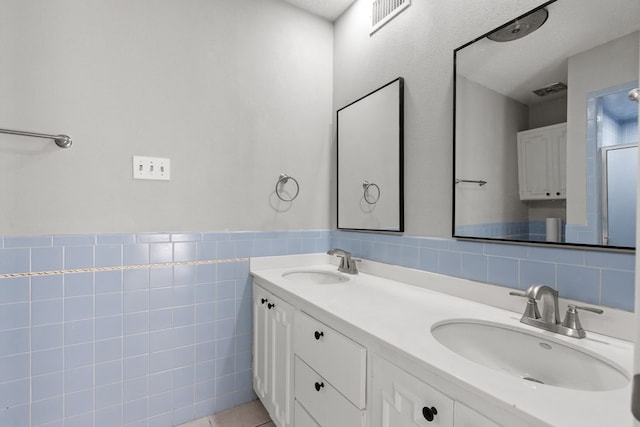 bathroom with a textured ceiling, tile walls, and vanity