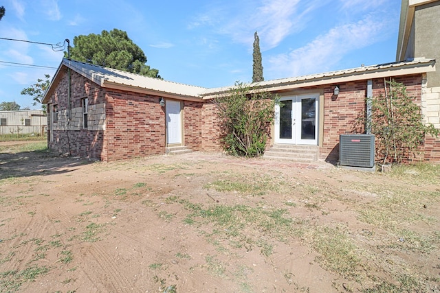 back of property with french doors and central AC