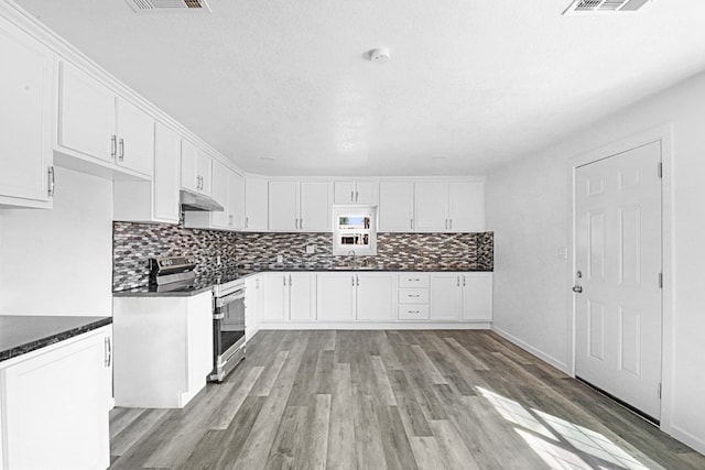 kitchen featuring white cabinetry, stainless steel electric range oven, backsplash, and light wood-type flooring