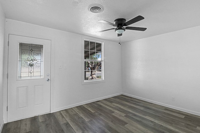 foyer entrance featuring ceiling fan, dark wood-type flooring, and a textured ceiling