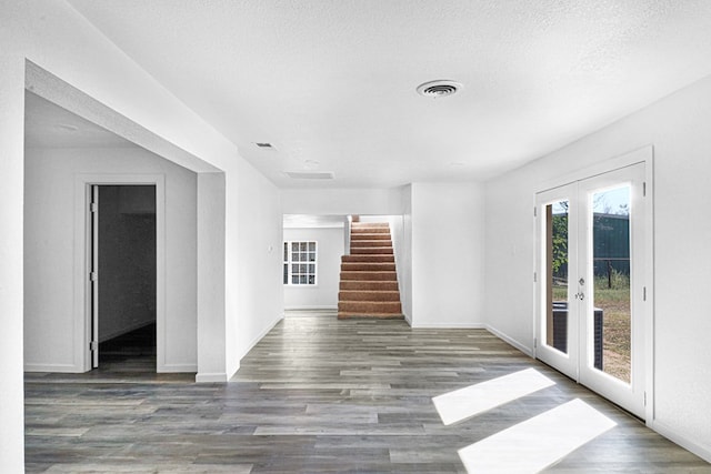 unfurnished room featuring dark hardwood / wood-style floors, french doors, and a textured ceiling