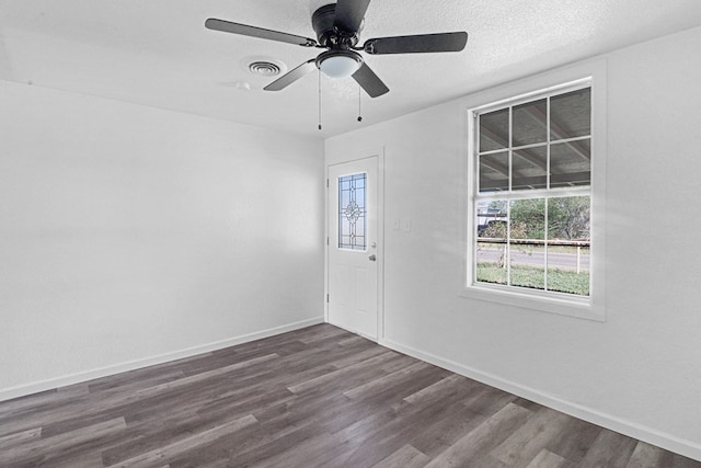 unfurnished room with ceiling fan, dark hardwood / wood-style floors, and a textured ceiling