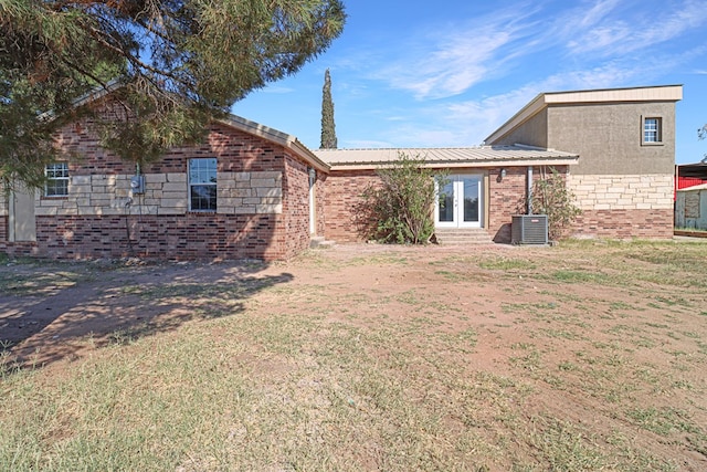 rear view of house with a yard and central AC unit