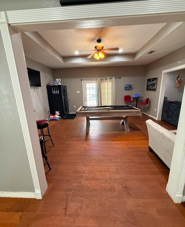 rec room featuring a tray ceiling, ceiling fan, and wood-type flooring