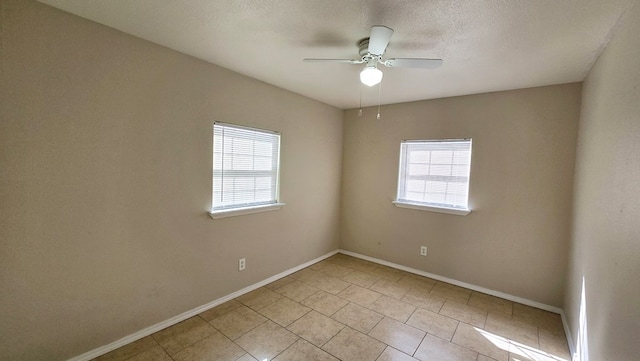 empty room featuring ceiling fan, a textured ceiling, and a wealth of natural light