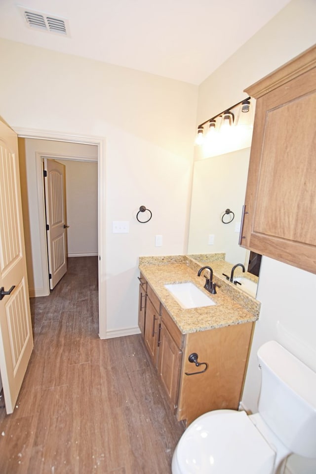 bathroom featuring hardwood / wood-style flooring, vanity, and toilet