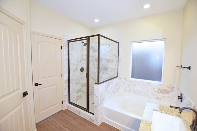 bathroom with wood-type flooring, vanity, and separate shower and tub