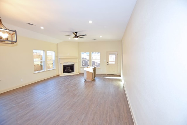 unfurnished living room with ceiling fan, dark wood-type flooring, and a premium fireplace