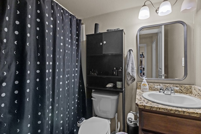 bathroom featuring a shower with shower curtain, toilet, vanity, and a textured wall