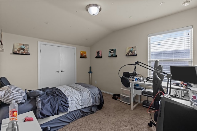 bedroom with a closet, baseboards, lofted ceiling, and carpet floors