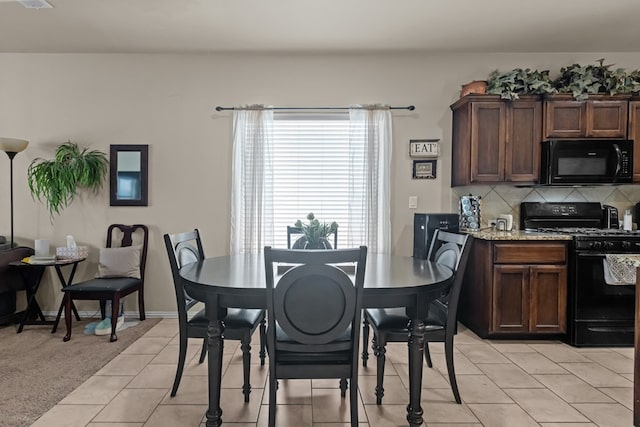 dining room featuring light tile patterned floors, baseboards, and light carpet