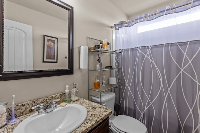 bathroom featuring a shower with shower curtain, toilet, and vanity