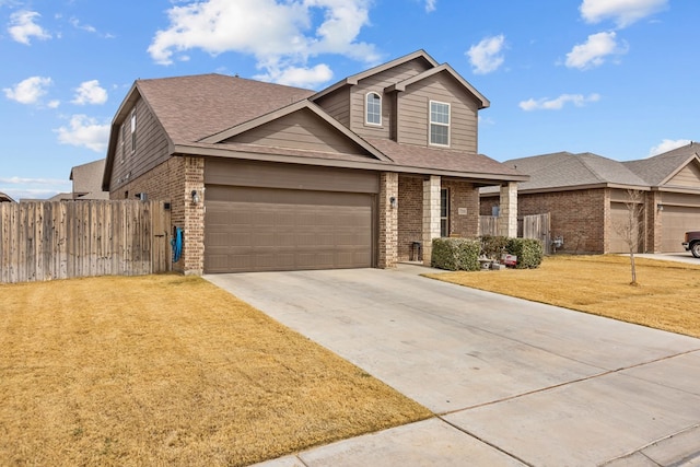 traditional-style home with a front yard, fence, an attached garage, concrete driveway, and brick siding