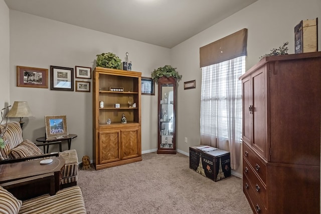 sitting room featuring light colored carpet and baseboards