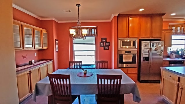 dining area with plenty of natural light, ornamental molding, and a chandelier