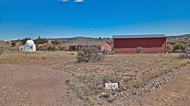 view of yard featuring a mountain view and a shed