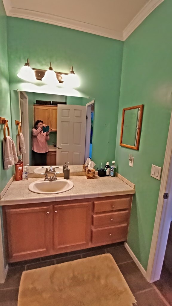 bathroom with tile patterned floors, vanity, and ornamental molding