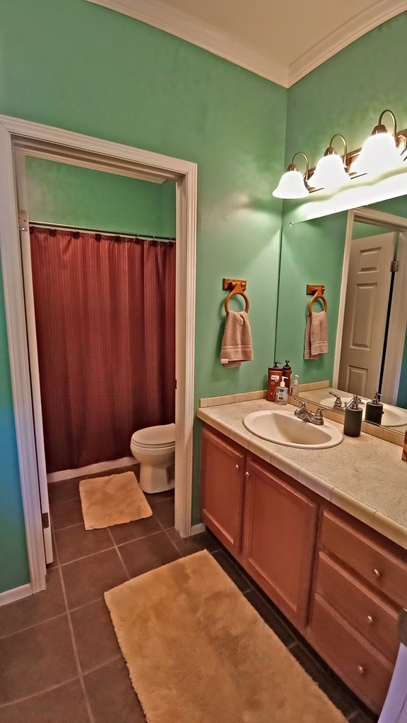 bathroom with crown molding, tile patterned flooring, vanity, and toilet