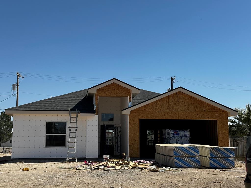 property in mid-construction featuring a garage and roof with shingles