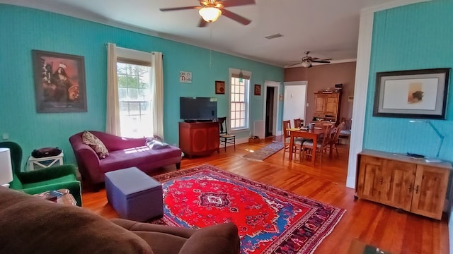 living room with a wealth of natural light, hardwood / wood-style floors, and ceiling fan