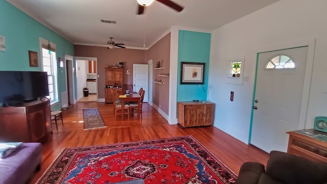 living room with crown molding, ceiling fan, a healthy amount of sunlight, and light hardwood / wood-style floors